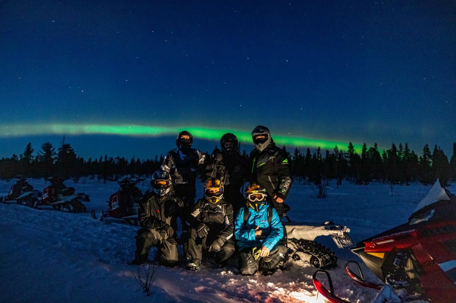 Gruppe unter Nordlicht in Lappland